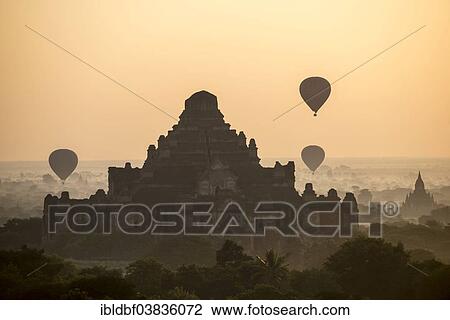 "Hot air balloons over the landscape in the early morning fog, Dhammayangyi Temple, stupas, pagodas, temple complex, Plateau of Bagan, Mandalay Division, Burma or Myanmar" View Large Photo Image Stock Image - "Hot air balloons over the landscape in the early morning fog, Dhammayangyi Temple, stupas, pagodas, temple complex, Plateau of Bagan, Mandalay Division, Burma or Myanmar". Fotosearch