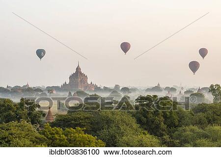 "Hot air balloons over the landscape in the early morning fog, temples, stupas, pagodas, temple complex, Plateau of Bagan, Mandalay Division, Burma or Myanmar" View Large Photo Image Stock Image - "Hot air balloons over the landscape in the early morning fog, temples, stupas, pagodas, temple complex, Plateau of Bagan, Mandalay Division, Burma or Myanmar". Fotosearch