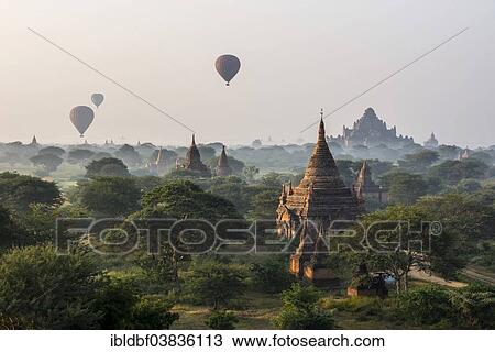 Stock Image - "Hot air balloons over the landscape in the early morning fog, Dhammayangyi Temple, stupas, pagodas, temple complex, Plateau of Bagan, Mandalay Division, Burma or Myanmar". Fotosearch