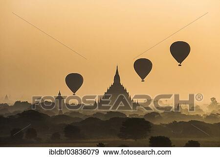Stock Photo - "Hot air balloons over the landscape in the early morning fog, temples, stupas, pagodas, temple complex, Plateau of Bagan, Mandalay Division, Burma or Myanmar". Fotosearch
