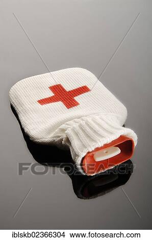 Picture - Hot water bottle in a woolen bag with a red cross. Fotosearch