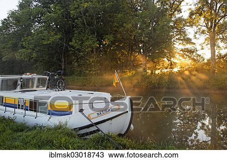 "Houseboat on the Canal des Vosges, formerly the Canal de l'Est, at PK 88, summit level of the canal, morning mood with morning fog, Les Forges, Epinal, Lorraine, Departement Vosges, France, Europe" View Large Photo Image Stock Image - "Houseboat on the Canal des Vosges, formerly the Canal de l'Est, at PK 88, summit level of the canal, morning mood with morning fog, Les Forges, Epinal, Lorraine, Departement Vosges, France, Europe". Fotosearch