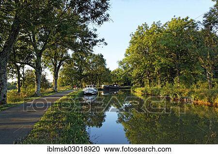 Stock Image - "Houseboat on the Canal des Vosges, formerly the Canal de l'Est, at PK 88, summit level of the canal, evening mood, Les Forges, Epinal, Lorraine, Departement Vosges, France, Europe". Fotosearch