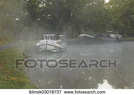 "Houseboat on the Canal des Vosges, formerly the Canal de l'Est, at PK 88, summit level of the canal, morning mood with morning fog, Les Forges, Epinal, Lorraine, Departement Vosges, France, Europe" View Large Photo Image Stock Photo - "Houseboat on the Canal des Vosges, formerly the Canal de l'Est, at PK 88, summit level of the canal, morning mood with morning fog, Les Forges, Epinal, Lorraine, Departement Vosges, France, Europe". Fotosearch