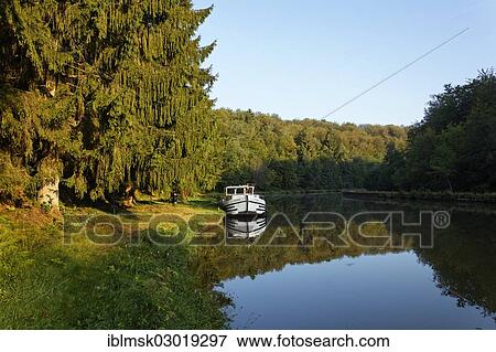 "Houseboat on the Canal des Vosges, formerly Canal de l'Est, landing in the forest at PK 115, morning mood, Thunimont, Epinal, Lorraine, Departement Vosges, France, Europe" View Large Photo Image Stock Photo - "Houseboat on the Canal des Vosges, formerly Canal de l'Est, landing in the forest at PK 115, morning mood, Thunimont, Epinal, Lorraine, Departement Vosges, France, Europe". Fotosearch
