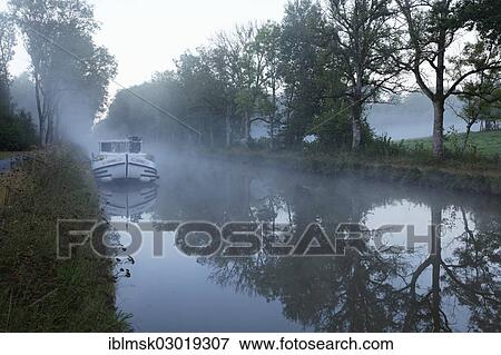 "Houseboat on the Canal des Vosges, formerly Canal de l'Est, overnight stay at PK 100. 5, with morning fog, Girancourt, Epinal, Lorraine, Departement Vosges, France, Europe" View Large Photo Image Stock Photo - "Houseboat on the Canal des Vosges, formerly Canal de l'Est, overnight stay at PK 100. 5, with morning fog, Girancourt, Epinal, Lorraine, Departement Vosges, France, Europe". Fotosearch