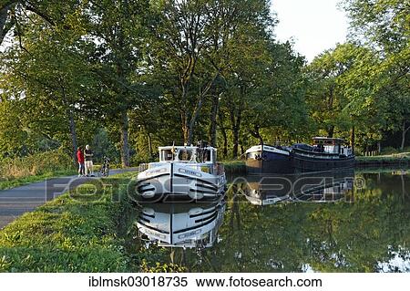 "Houseboat on the Canal des Vosges, formerly the Canal de l'Est, at PK 88, summit level of the canal, evening mood, Les Forges, Epinal, Lorraine, Departement Vosges, France, Europe" View Large Photo Image Stock Photography - "Houseboat on the Canal des Vosges, formerly the Canal de l'Est, at PK 88, summit level of the canal, evening mood, Les Forges, Epinal, Lorraine, Departement Vosges, France, Europe". Fotosearch