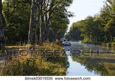 Stock Photography - "Houseboat on the Canal des Vosges, formerly Canal de l'Est, at PK 100. 5, evening mood, Girancourt, Epinal, Lorraine, Departement Vosges, France, Europe". Fotosearch