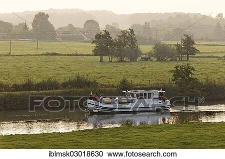 Stock Image - "Houseboat, penichette, on the Saone River, early morning at Baulay, PK 380, Fouchecourt, Vesoul, Region Franche-Comte, Dep. Haute-Saone, France, Europe". Fotosearch