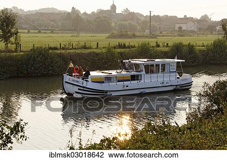 Stock Image - "Houseboat, penichette, on the Saone River, early morning at Baulay, PK 380, Fouchecourt, Vesoul, Region Franche-Comte, Dep. Haute-Saone, France, Europe". Fotosearch