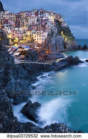 Stock Image - "Houses of Manarola on the rocky coast at dusk, UNESCO World Cultural Heritage Site, Manarola, Cinque Terre, Liguria, Italy, Europe". Fotosearch