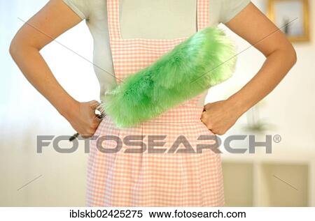 "Housewife wearing an apron and holding a feather duster, detail" View Large Photo Image Stock Photography - "Housewife wearing an apron and holding a feather duster, detail". Fotosearch