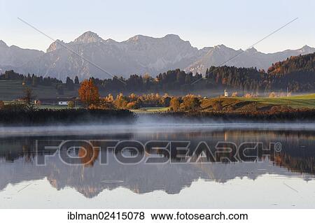 Huttlerweiher pond, Rosshaupten, Tannheimer Berge mountains in the back, Ostallgaeu, Allgaeu, Swabia, Bavaria, Germany, Europe View Large Photo Image Stock Photo - Huttlerweiher pond, Rosshaupten, Tannheimer Berge mountains in the back, Ostallgaeu, Allgaeu, Swabia, Bavaria, Germany, Europe. Fotosearch
