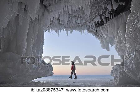 "Ice formations and icicles hanging from ceiling in a cave and a man walking on frozen Lake Superior, Apostle Islands National Lakeshore, Bayfield, Wisconsin, USA" View Large Photo Image Stock Photo - "Ice formations and icicles hanging from ceiling in a cave and a man walking on frozen Lake Superior, Apostle Islands National Lakeshore, Bayfield, Wisconsin, USA". Fotosearch