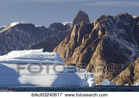 "Iceberg in front of the mountain scenery of Ofjord, Grundtvigskirken Mountain at the rear, Bjorneoer, Scoresbysund, Sermersooq, Greenland, North America" View Large Photo Image Stock Photo - "Iceberg in front of the mountain scenery of Ofjord, Grundtvigskirken Mountain at the rear, Bjorneoer, Scoresbysund, Sermersooq, Greenland, North America". Fotosearch