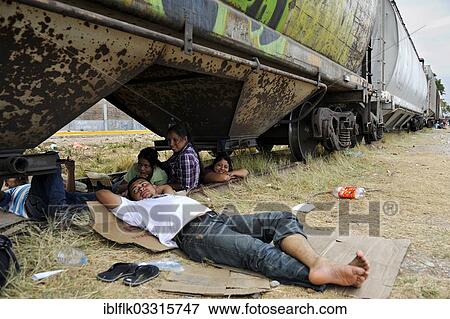 "Illegal immigrants from Latin America on their way to the U. S., waiting at a station for the next freight train to board as stowaways, Ixtepec, Oaxaca, Mexico, North America" View Large Photo Image Stock Photo - "Illegal immigrants from Latin America on their way to the U. S., waiting at a station for the next freight train to board as stowaways, Ixtepec, Oaxaca, Mexico, North America". Fotosearch