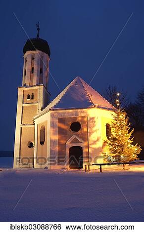 "Illuminated chapel at dusk in winter with a Christmas tree, Adelzhausen, Bavaria, Germany, Europe" View Large Photo Image Stock Photograph - "Illuminated chapel at dusk in winter with a Christmas tree, Adelzhausen, Bavaria, Germany, Europe". Fotosearch