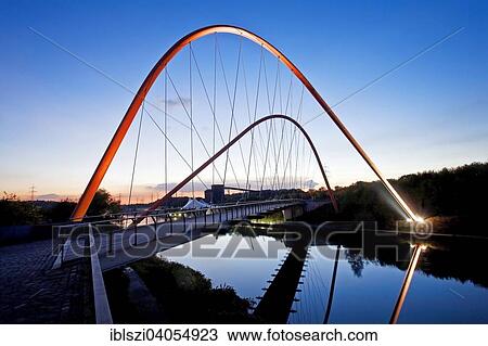 Stock Image - "Illuminated double arch bridge over the Rhine-Herne Canal, Nordsternpark, former Nordstern colliery, Gelsenkirchen, North Rhine-Westphalia, Germany, Europe". Fotosearch