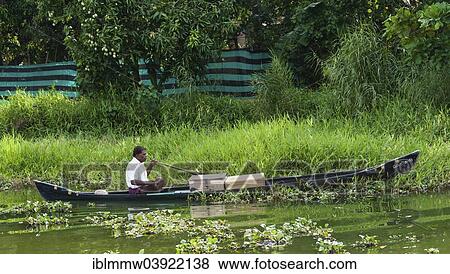 "Indian man steering a boat, Backwaters, Alappuzha District, Alleppey, Kerala, India, Asia" View Large Photo Image Stock Photo - "Indian man steering a boat, Backwaters, Alappuzha District, Alleppey, Kerala, India, Asia". Fotosearch