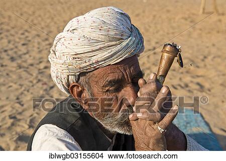 Picture - "Indian man with a turban smoking a hash pipe, Pushkar, Rajasthan, India, Asia". Fotosearch