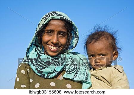 "Indian woman with headscarf holding a little boy in her arms, portrait, Pushkar, Rajasthan, India, Asia" View Large Photo Image Stock Photo - "Indian woman with headscarf holding a little boy in her arms, portrait, Pushkar, Rajasthan, India, Asia". Fotosearch