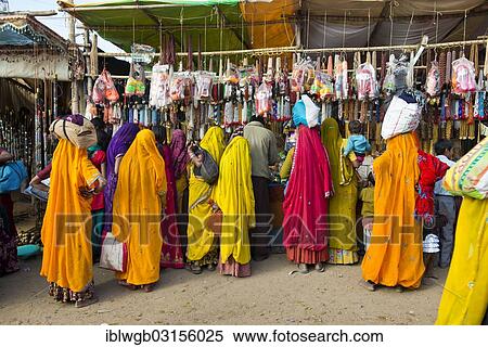 "Indian women in colorful saris standing in front of a stall selling toys and fashion jewellery, Pushkar Camel Fair, Pushkar, Rajasthan, India, Asia" View Large Photo Image Stock Photography - "Indian women in colorful saris standing in front of a stall selling toys and fashion jewellery, Pushkar Camel Fair, Pushkar, Rajasthan, India, Asia". Fotosearch