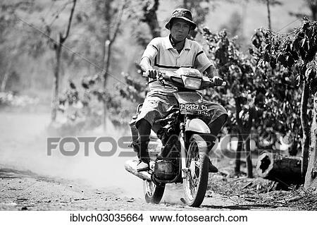 Picture - "Indonesian man riding a motorcycle, Java, Indonesia, Asia". Fotosearch