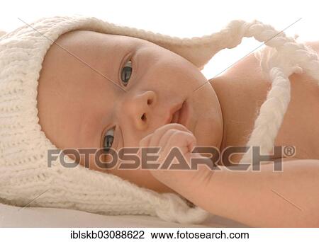 Stock Image - "Infant wearing white woollen hat, lying, bare torso". Fotosearch
