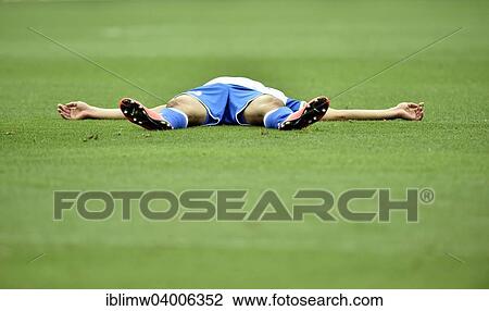 Stock Image - "Injured football player lying on the ground, Rhein Neckar Arena, Sinsheim, Baden-Wurttemberg, Germany, Europe". Fotosearch