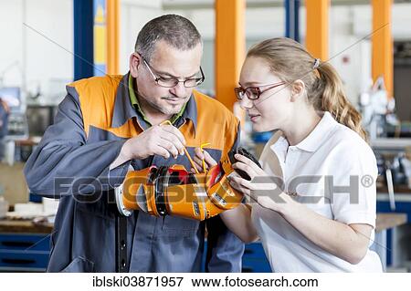 "Instructor explaining a robot hand to a trainee for mechatronics assembly work, training center of the robot manufacturer KUKA AG, Augsburg, Bavaria, Germany, Europe" View Large Photo Image Stock Photo - "Instructor explaining a robot hand to a trainee for mechatronics assembly work, training center of the robot manufacturer KUKA AG, Augsburg, Bavaria, Germany, Europe". Fotosearch
