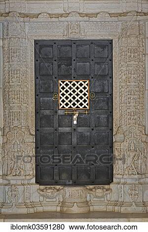 Stock Image - "Iron door framed by ornate columns, marble temple, temple of the Jain religion, Adinatha Temple, Ranakpur, Rajasthan, India, Asia". Fotosearch
