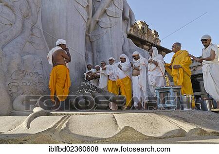 "Jain pilgrims doing a special pooja in front of the gigantic statue to receive the blessings of Bahubali by the local priests, Sravanabelagola, India, Asia" View Large Photo Image Stock Photo - "Jain pilgrims doing a special pooja in front of the gigantic statue to receive the blessings of Bahubali by the local priests, Sravanabelagola, India, Asia". Fotosearch