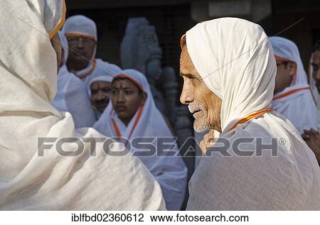 "Jain pilgrims reciting religious texts at the feet of the gigantic statue of Gomateshwara in Sravanabelagola, India, Asia" View Large Photo Image Stock Image - "Jain pilgrims reciting religious texts at the feet of the gigantic statue of Gomateshwara in Sravanabelagola, India, Asia". Fotosearch