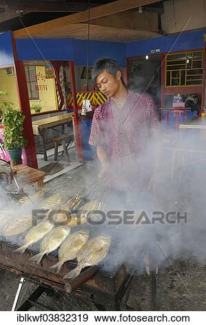 "Javanese man grilling fish in a restaurant, Biak city, Biak Island, West Papua, Indonesia, Asia" View Large Photo Image Stock Photo - "Javanese man grilling fish in a restaurant, Biak city, Biak Island, West Papua, Indonesia, Asia". Fotosearch