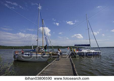 Stock Image - "Jetty for sailing boats, near Ruciane-Nida, Warmian-Masurian Voivodeship, Poland, Europe". Fotosearch