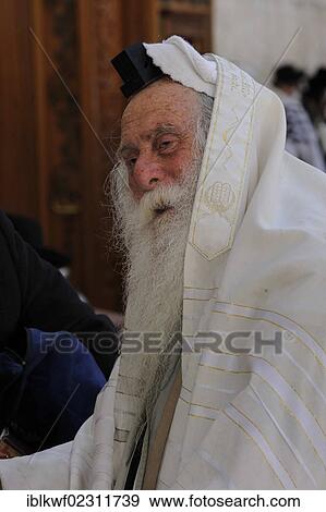 Stock Photo - "Jew in front of the Torah cabinet with a tefillin on his head and a prayer shawl, tallit, around his head, Muslim Quarter, Jerusalem, Israel, Middle East, Southwest Asia, Asia". Fotosearch