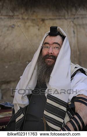 Stock Image - "Jew with tefillin on his head and prayer shawl, tallit, around the head, Muslim Quarter, Jerusalem, Israel, Middle East, Southwest Asia, Asia". Fotosearch