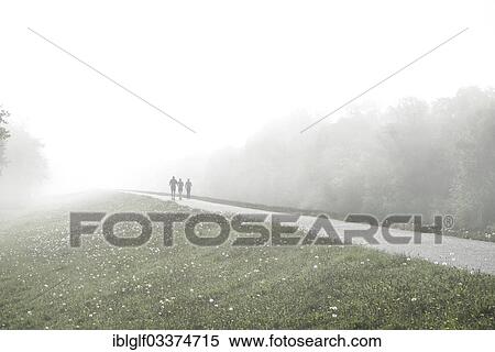 "Joggers jogging along a dyke in the fog, Zingst, Fischland-Darss-Zingst, Mecklenburg-Western Pomerania, Germany, Europe" View Large Photo Image Stock Photography - "Joggers jogging along a dyke in the fog, Zingst, Fischland-Darss-Zingst, Mecklenburg-Western Pomerania, Germany, Europe". Fotosearch