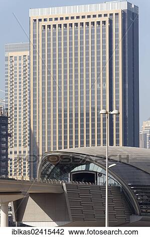 Stock Image - Jumeirah Lake Towers Metro Station in front of a skyscraper, Dubai, United Arab Emirates, Middle East, Asia. Fotosearch