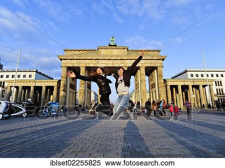 Stock Photography - "Jumping for joy, two girls jumping in the air in front of the Brandenburg Gate, Berlin, Germany, Europe". Fotosearch