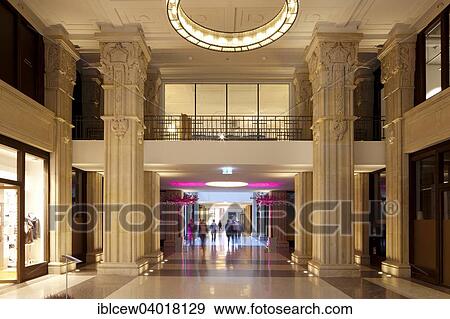 Stock Photo - "Kaisergalerie mall, atrium with terrazzo floor, design ring light on renovated coffered ceiling and 7. 50 meter high sandstone pillars with carved crowns and ornaments, Hamburg, Germany, Europe". Fotosearch