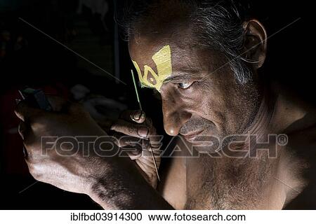 Stock Image - "Katakali artist applying makeup, Varkala, Kerala, India, Asia". Fotosearch