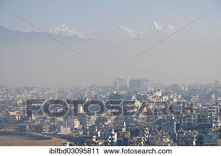 Stock Image - "Kathmandu Valley in smog, snowy mountains at back, Kathmandu Valley, Kathmandu, Kathmandu District, Bagmati Zone, Nepal, Asia". Fotosearch