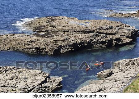 Stock Photo - "Kayakers off the rocky coast near Rosudgeon, Cornwall, England, Great Britain, Europe". Fotosearch