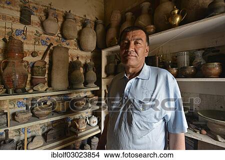 "Kazakh antiques dealer in his antique shop, Uyghur Muslim Quarter, Kashgar, Seidenstrasse, Xinjiang, China, People's Republic of China, Asia" View Large Photo Image Picture - "Kazakh antiques dealer in his antique shop, Uyghur Muslim Quarter, Kashgar, Seidenstrasse, Xinjiang, China, People's Republic of China, Asia". Fotosearch