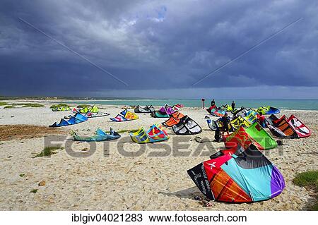 Stock Image - "Kites and kitesurfers on the beach in high winds, Mari Ermi, Sinis peninsula, Oristano Province, Sardinia, Italy, Europe". Fotosearch