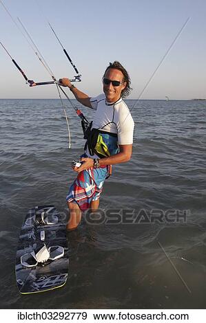 "Kitesurfer standing in water with the kite, El Gouna, Red Sea Governorate, Egypt, Africa" View Large Photo Image Stock Photo - "Kitesurfer standing in water with the kite, El Gouna, Red Sea Governorate, Egypt, Africa". Fotosearch