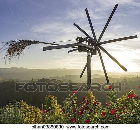 Stock Image - "Klapotetz bird scarer with roses and a vineyard in the evening light, Spicnik, Pesnica, Slovenia, Europe". Fotosearch