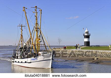 Stock Image - "Kleiner Preusse or Little Prussian Lighthouse, cutter entering the harbour, North Sea resort of Wremen, Cuxhaven district, Lower Saxony, Germany, Europe". Fotosearch