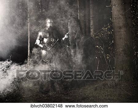 Stock Photo - "Knight wearing armour standing beside his horse in the woods, Tyrol, Austria, Europe". Fotosearch